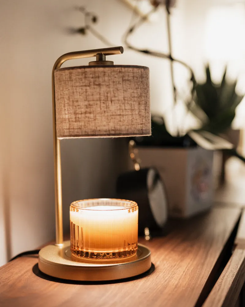 A warm candle lamp on a wooden cabinet