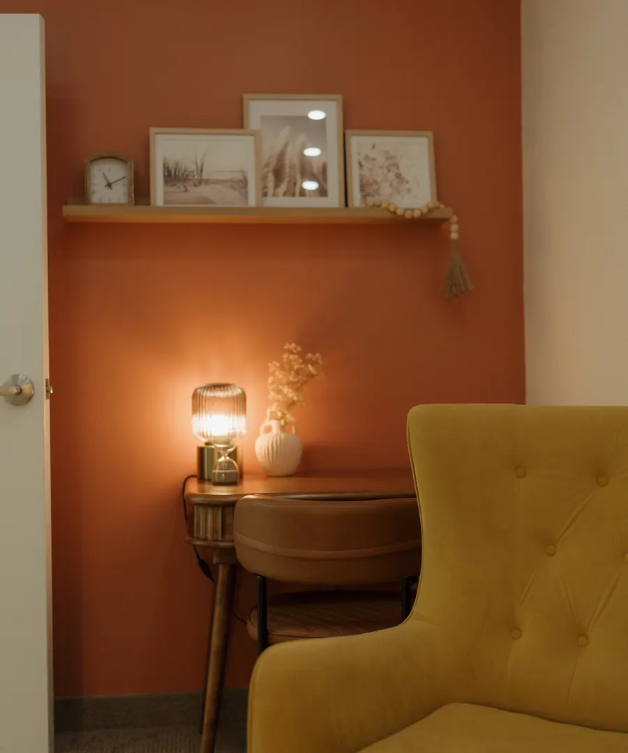 A corner of the St. Catharines office: a terracotta wall, a small lamp, and a velvet armchair
